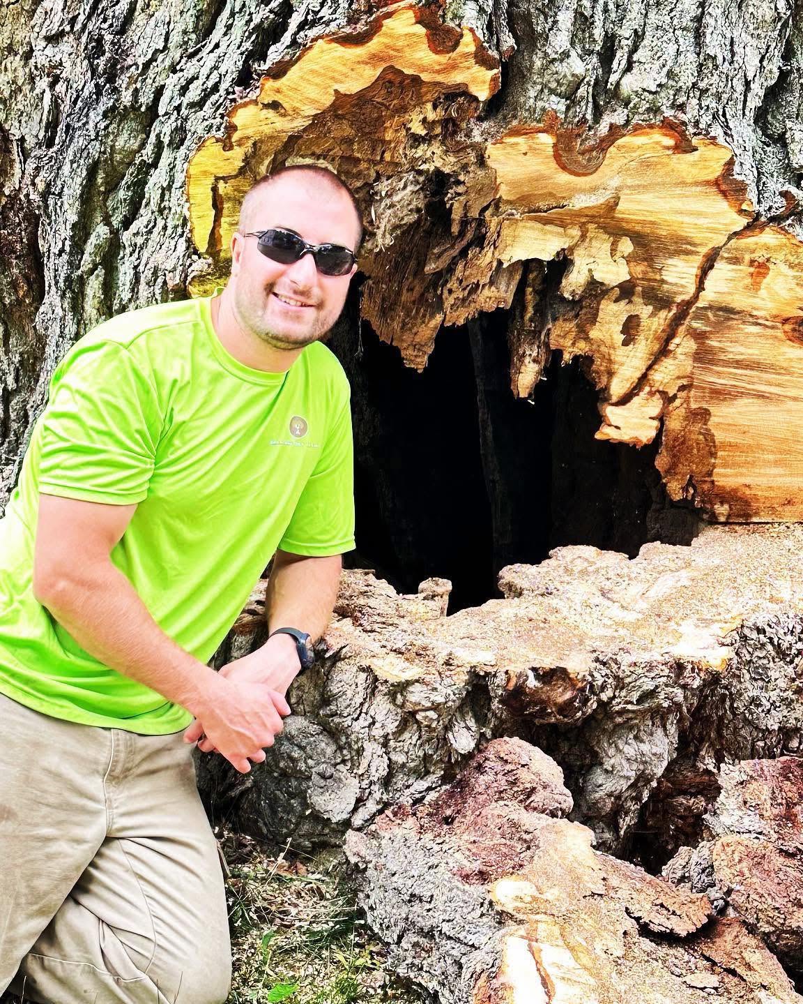Jason Thibodeau, owner of Branching Out Tree Care, beside a large hollow tree trunk removed in Coventry Connecticut